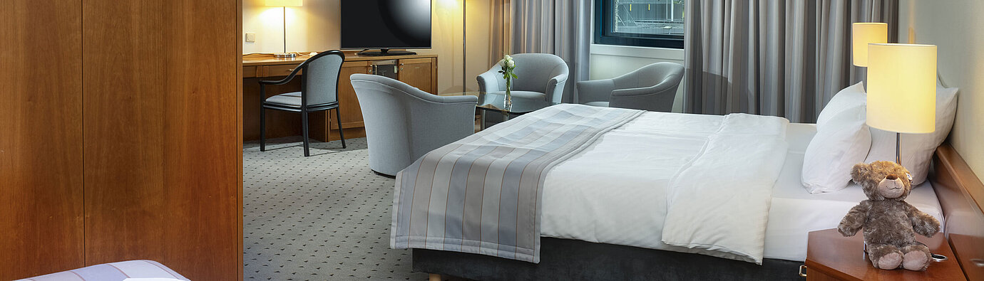Classic Family room Spacious family room with double bed, seating area, and airport view at Maritim Hotel Hannover.
