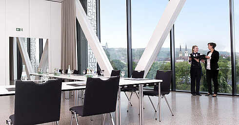 Modern meeting room at Maritim Hotel Würzburg with large window, view and two people talking