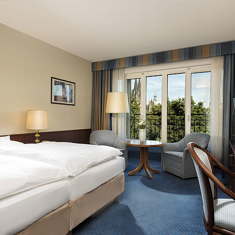 Superior double room at Maritim Hotel Cologne with cozy decor and view of the Cologne Cathedral.