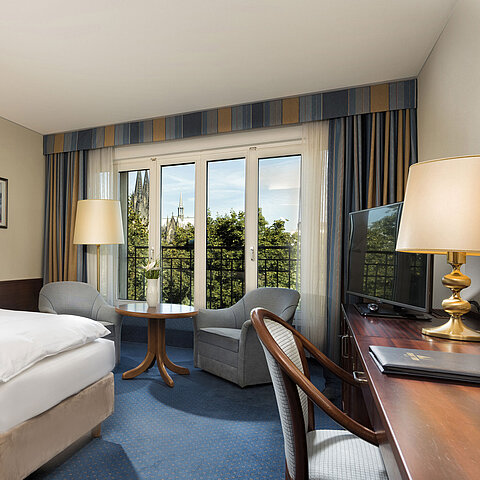 Superior double room at Maritim Hotel Cologne with cozy decor and view of the Cologne Cathedral.