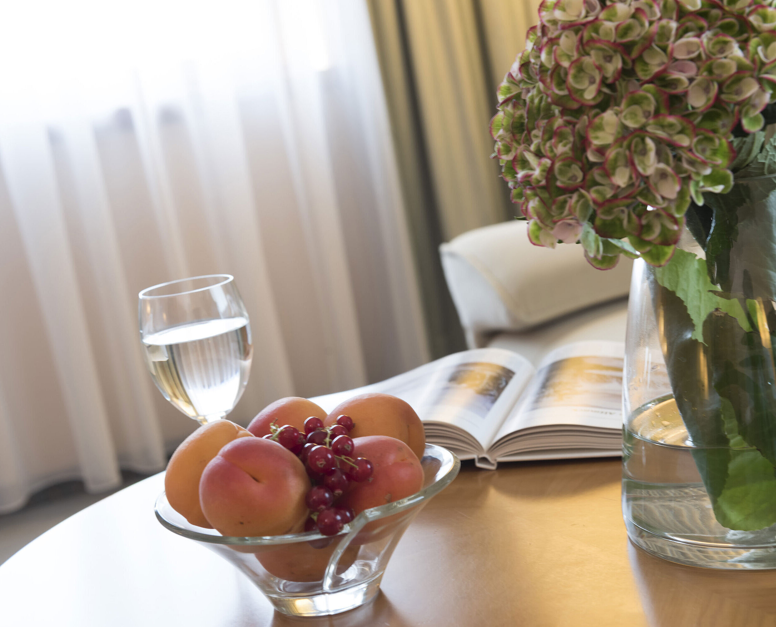 Studio Glass of water, fruit bowl and hydrangea vase on the table at Maritim Hotel Magdeburg