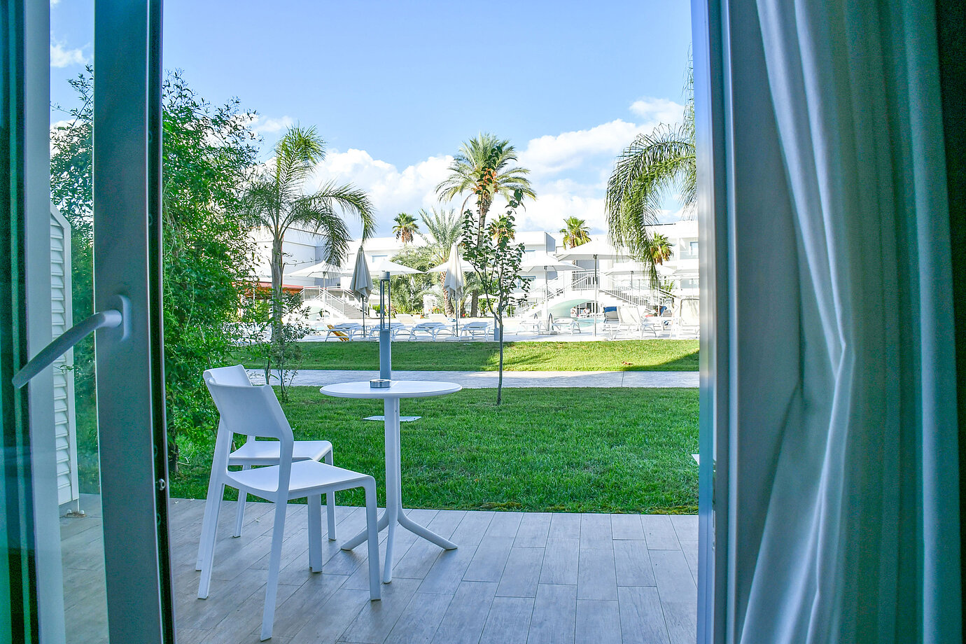Private terrace on the ground floor of Maritim Resort Calabria with view of greenery and pool