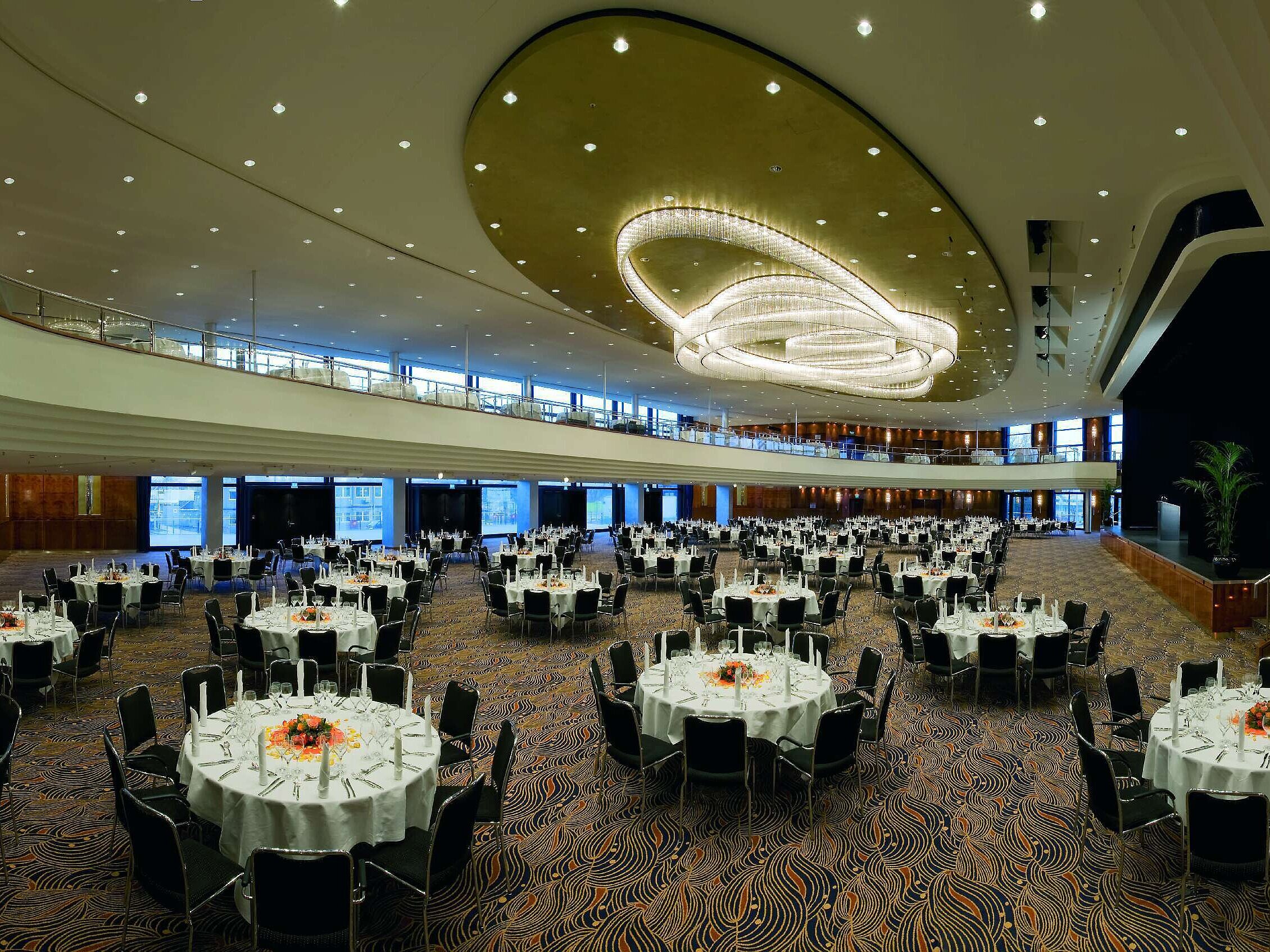 Elegant event hall at Maritim Hotel Düsseldorf, festively arranged with round tables and impressive lighting.
