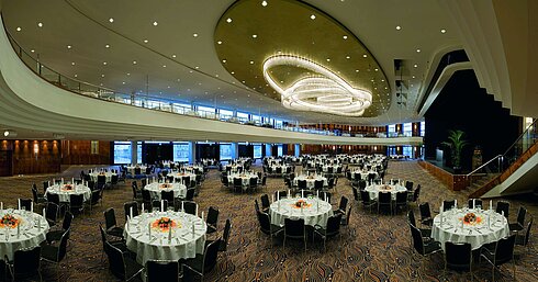 Elegant event hall at Maritim Hotel Düsseldorf, festively arranged with round tables and impressive lighting.