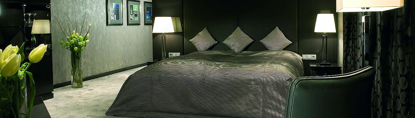 Bedroom of the Master Suite at Maritim Hotel Düsseldorf with a luxurious double bed, modern lighting, and elegant decor.