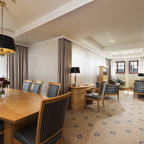 Spacious Executive Suite at Maritim Hotel Dresden with elegant dining table, comfortable seating area, and city view.