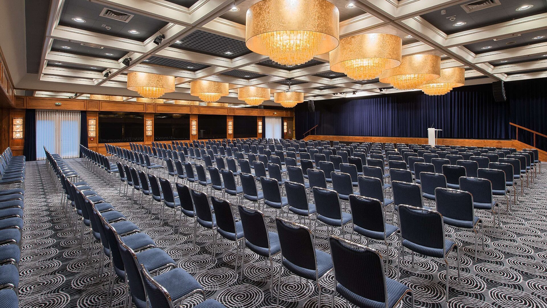 Elegant hall at Maritim Hotel Darmstadt featuring row seating, stunning chandeliers, and perfect setup for events.