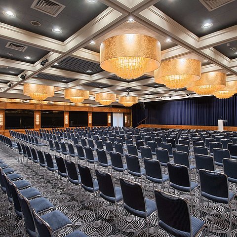 Elegant hall at Maritim Hotel Darmstadt featuring row seating, stunning chandeliers, and perfect setup for events.