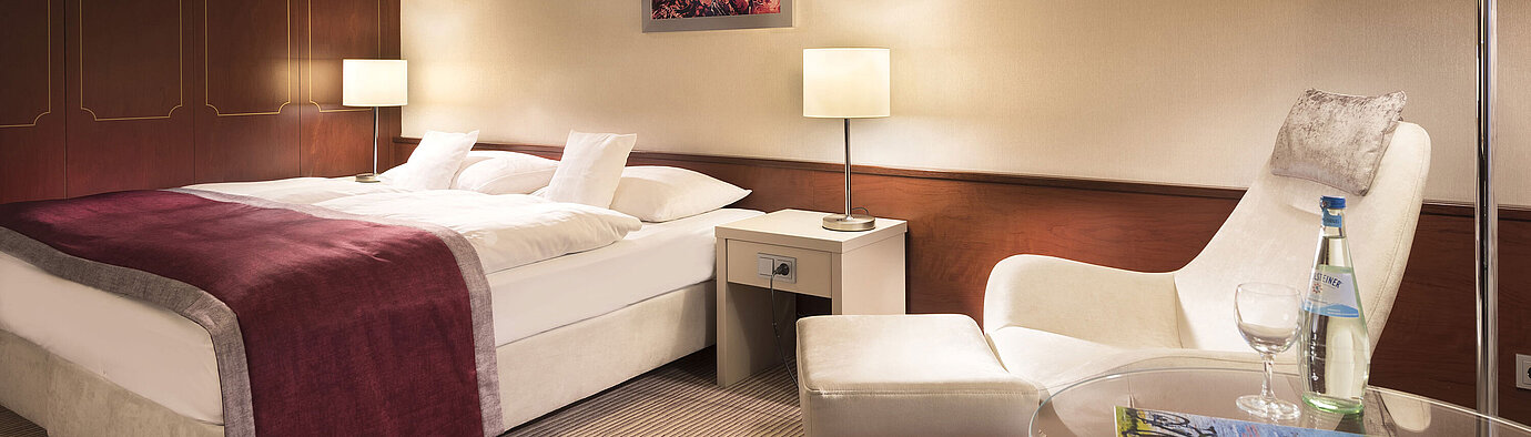 Classic room at Maritim Hotel Bonn, comfortably furnished with double bed, armchair, table, and modern lighting.