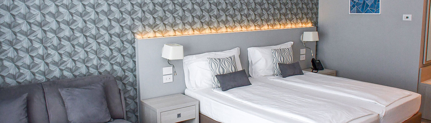 Superior room Spacious room at Maritim Resort Calabria with twin bed, sofa and stylish wall design