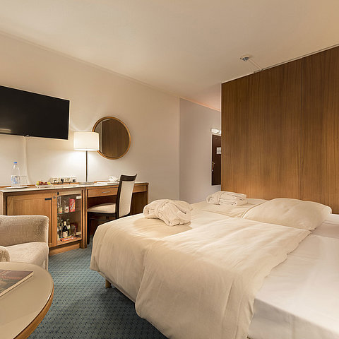 Classic room at Maritim Seehotel Timmendorfer Strand with twin beds, minibar, desk, TV, and seating area.
