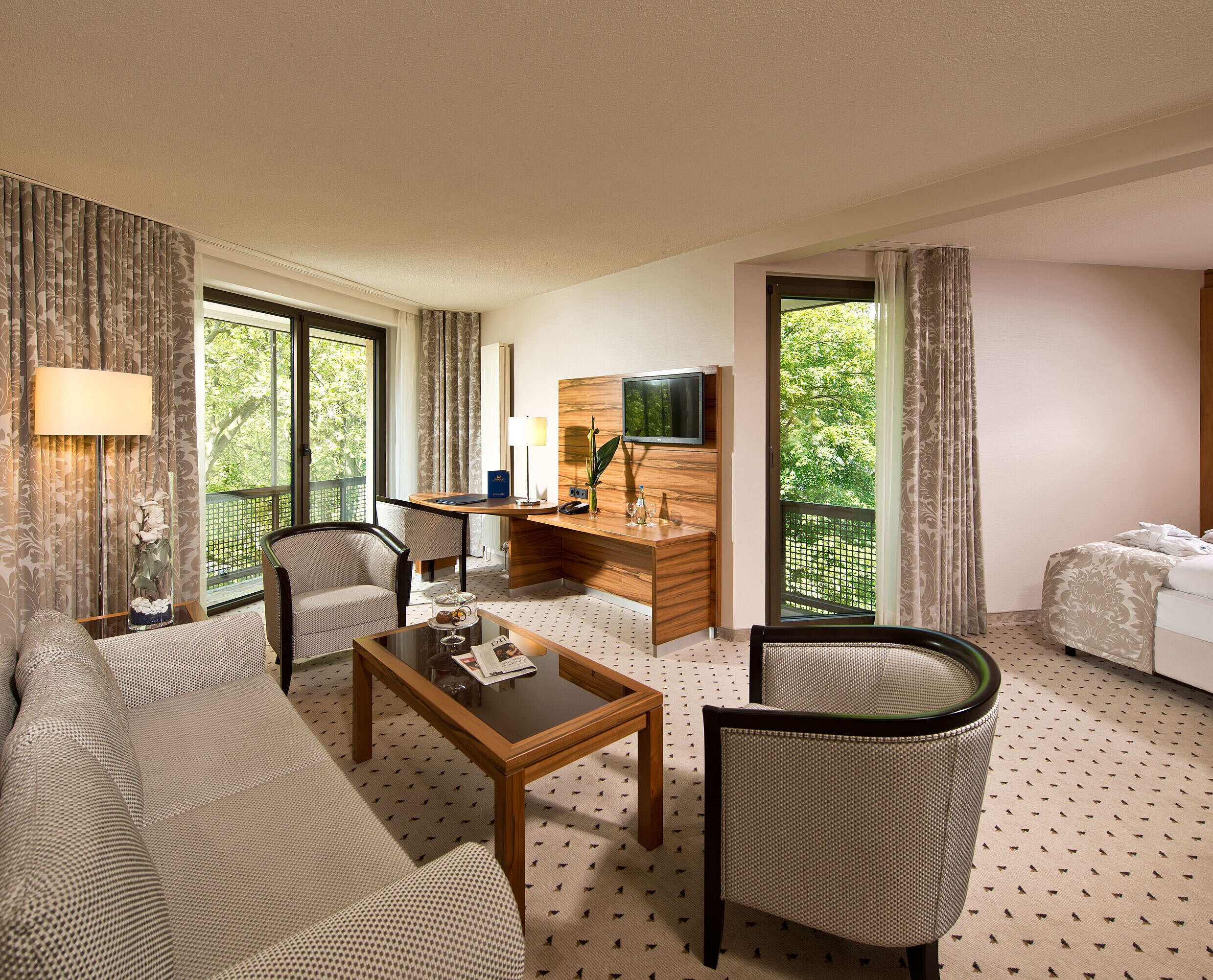 Studio room Spacious suite at Maritim Hotel Bad Homburg with separate living area, balcony, and green view.