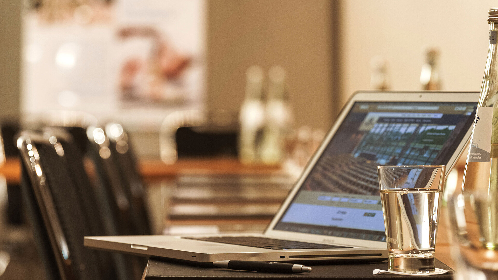 Laptop, pen and glass of water on table in the conference room at the Maritim Hotel Munich