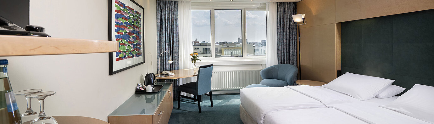 Comfort room with double bed, desk and cosy seating area at Maritim proArte Hotel Berlin