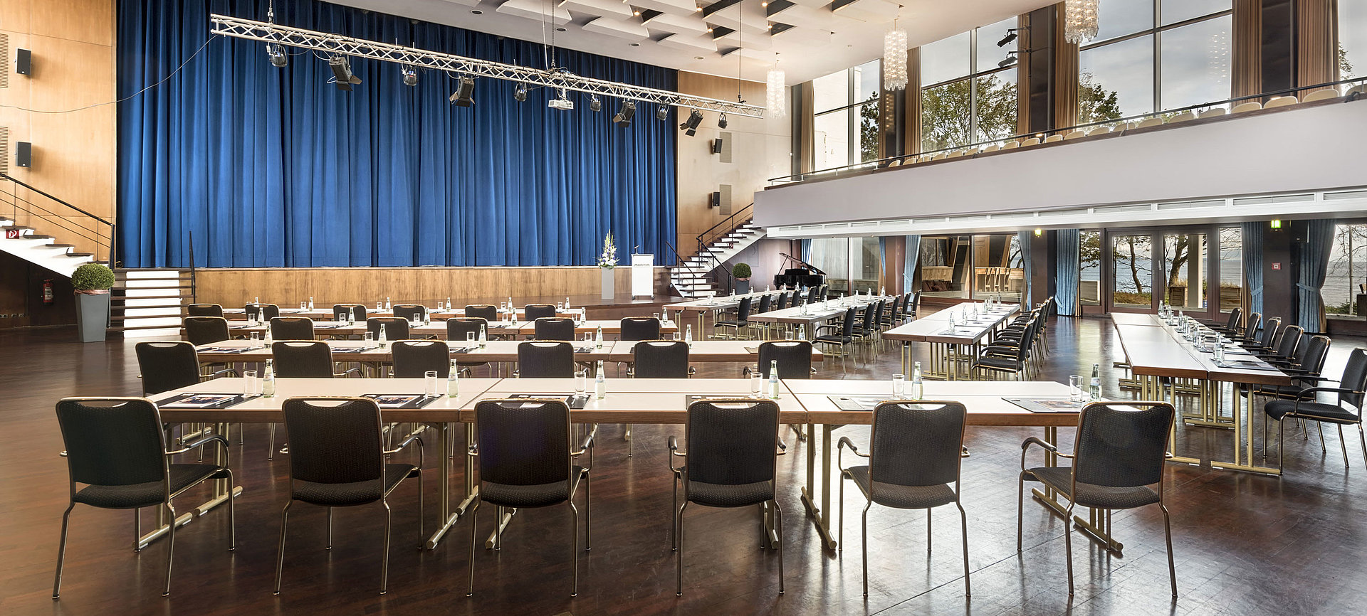 Grand Hall "Maritim" at Maritim Seehotel Timmendorfer Strand with stage, blue curtains, and conference seating.