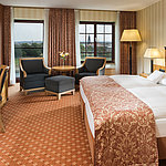 Superior room at Maritim Hotel Dresden with elegant double bed, desk, and seating area with city view.