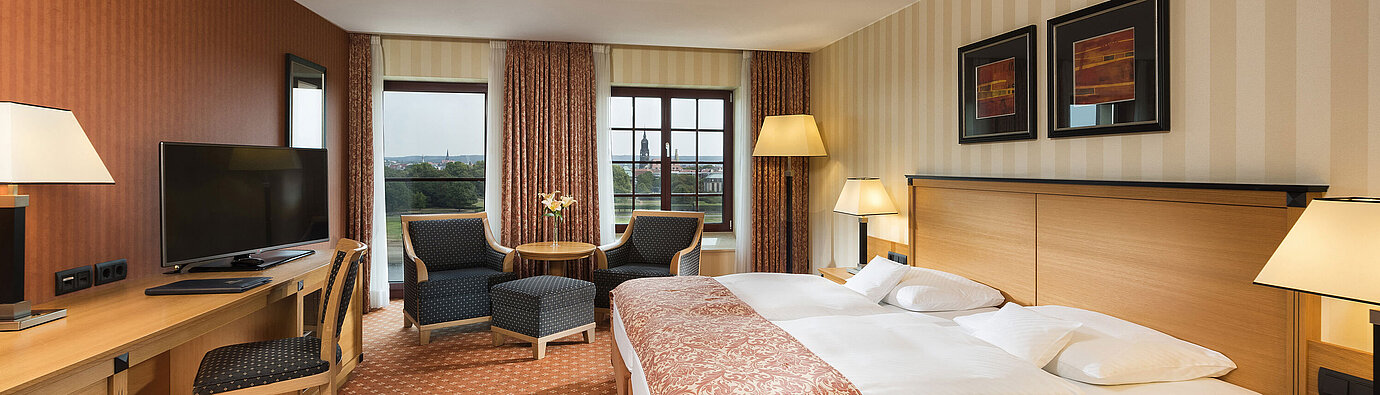 Superior room Superior room at Maritim Hotel Dresden with elegant double bed, desk, and seating area with city view.