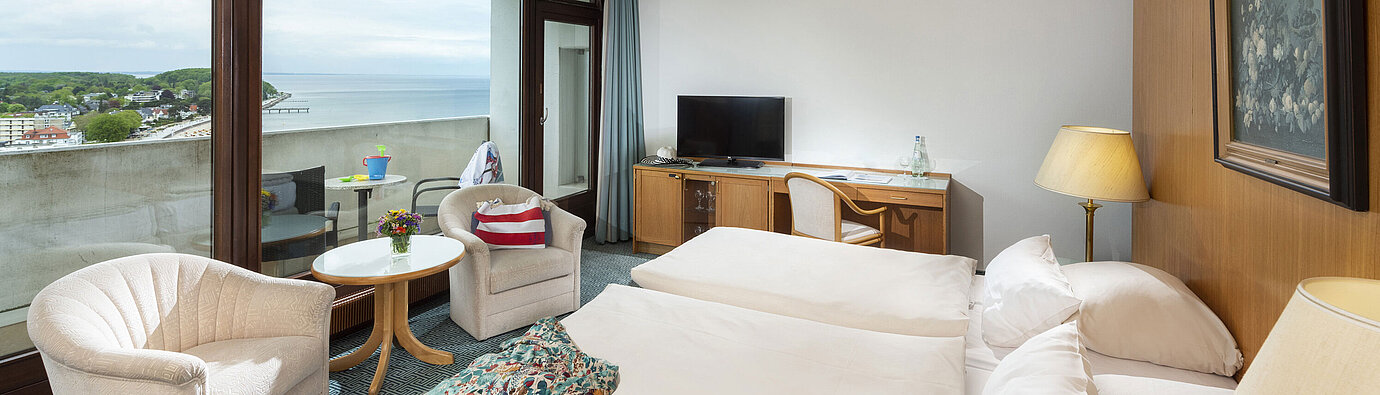 Family room Comfortable room with two armchairs and sea view balcony at Maritim Hotel Travemünde