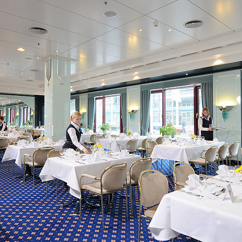 Salon Bonn conference room at Maritim Hotel Magdeburg with white-clothed tables, elegant décor, and friendly service staff.
