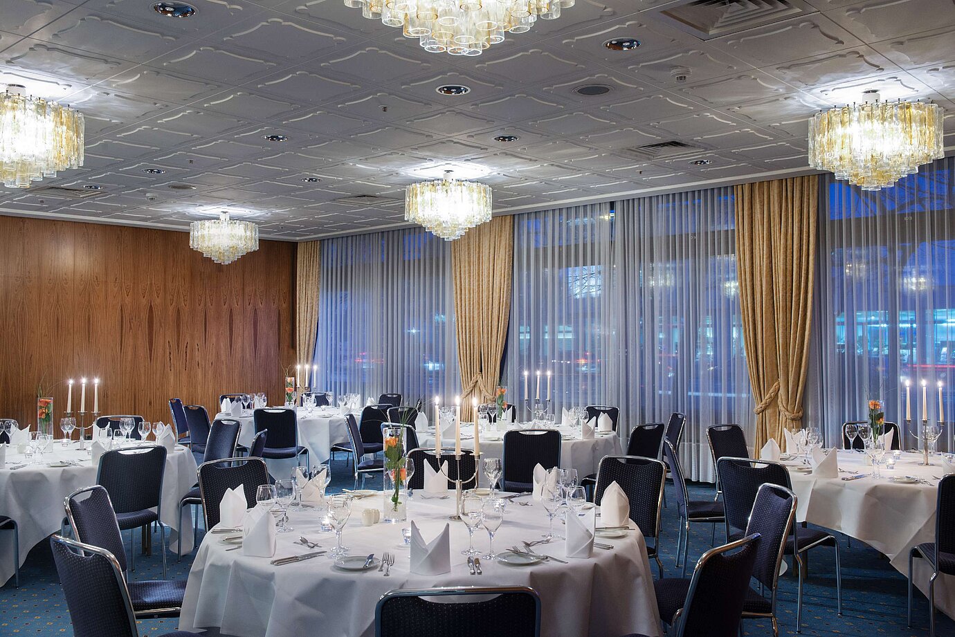 Elegantly set event room at Maritim Hotel Darmstadt with round tables, candles, and a sophisticated ambiance.