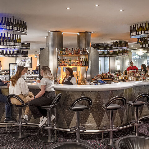 Elegant bar at Maritim proArte Hotel Berlin where guests enjoy relaxed conversations and a wide selection of drinks.
