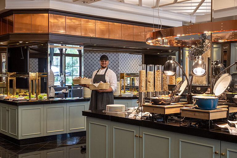 Restaurant Landgraf Staff member at the breakfast buffet in Restaurant Landgraf, Maritim Hotel Darmstadt, with fresh pastries