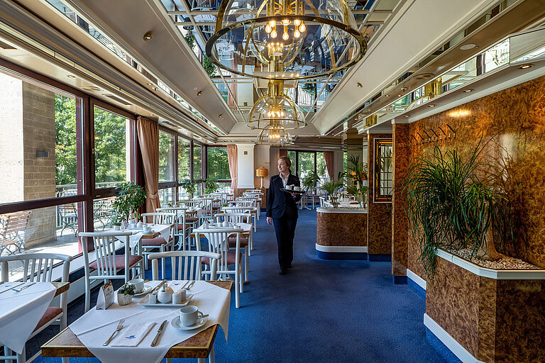 Restaurant at Maritim Hotel Cologne with staff and large windows overlooking greenery