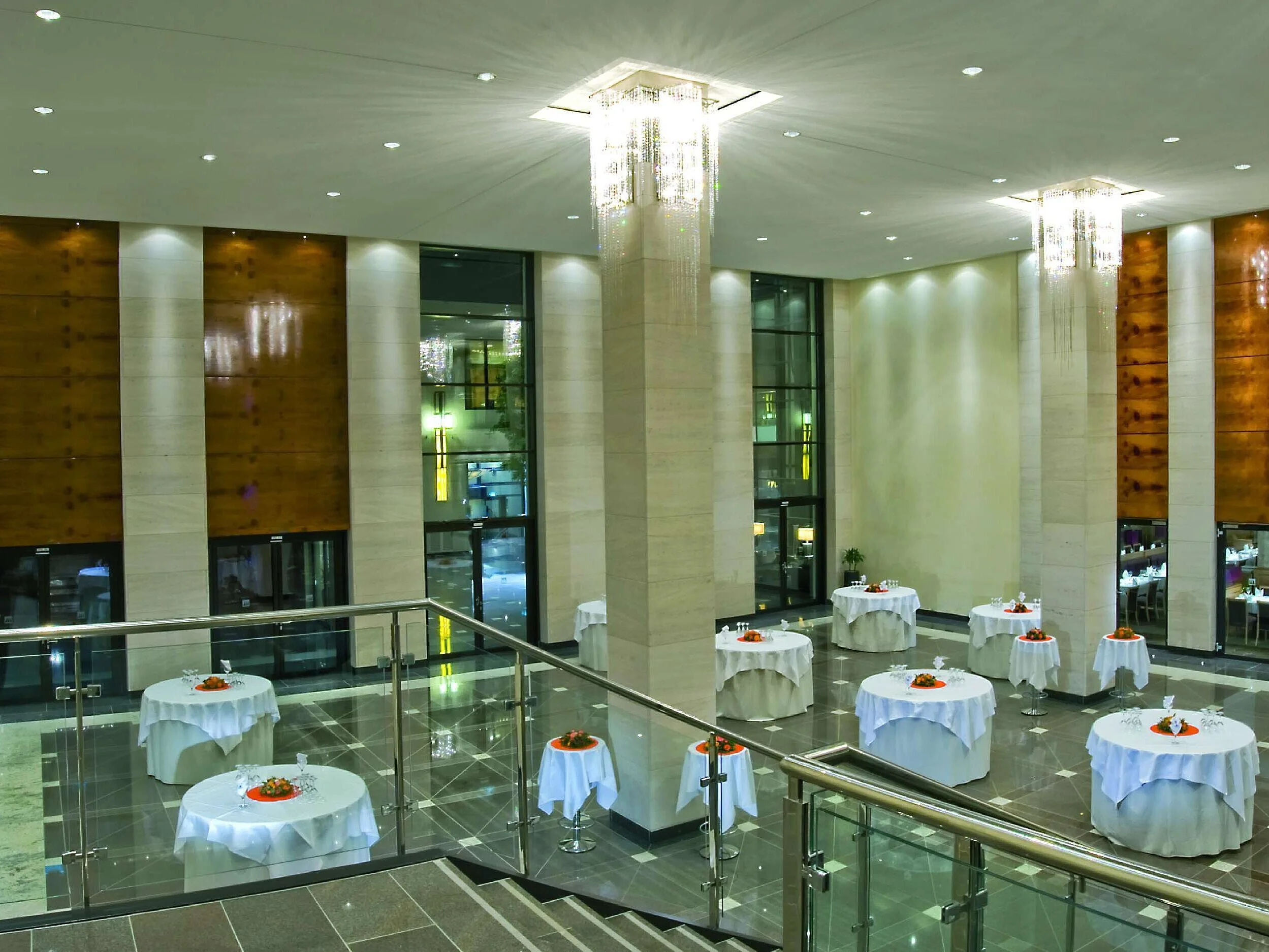 Elegant hall foyer at Maritim Hotel Düsseldorf with high ceilings, stylishly set standing tables, and modern lighting.