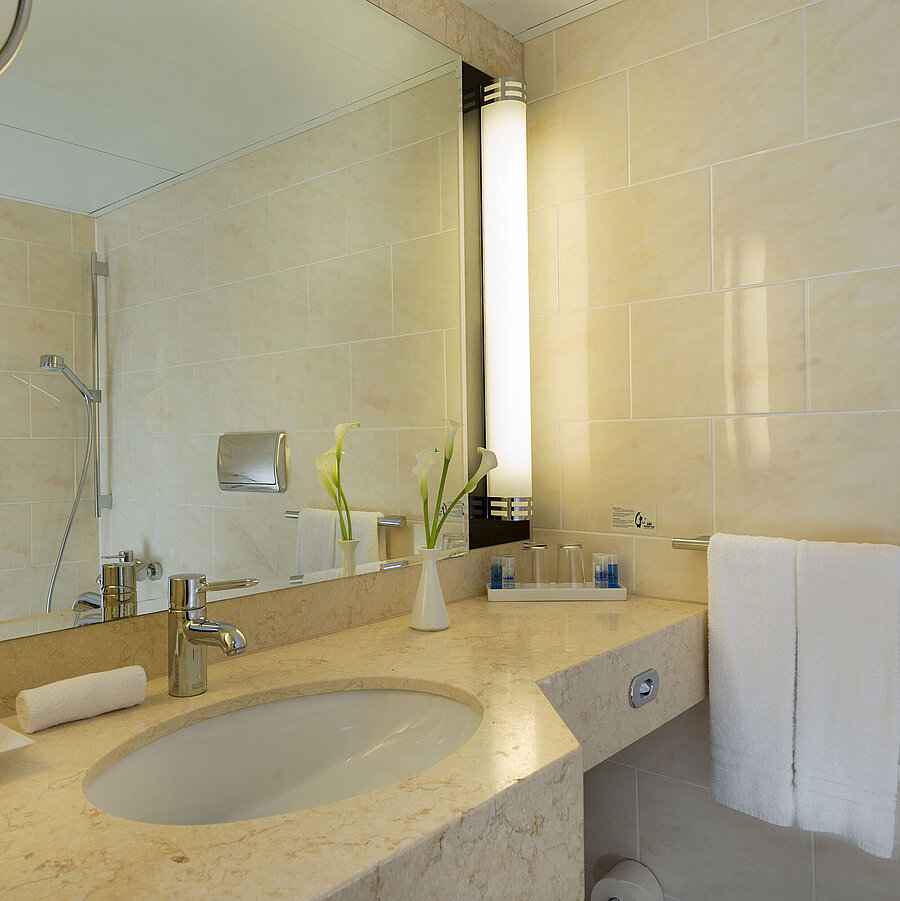 Bathroom Modern bathroom at Maritim Hotel Fulda with marble sink, large mirror, and walk-in shower.