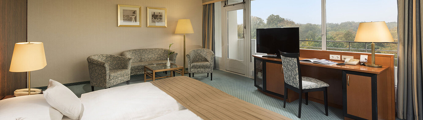 Comfort room Comfort room at the Maritim Hotel Kiel with a cozy seating area, desk, large bed and a wonderful view of the countryside.