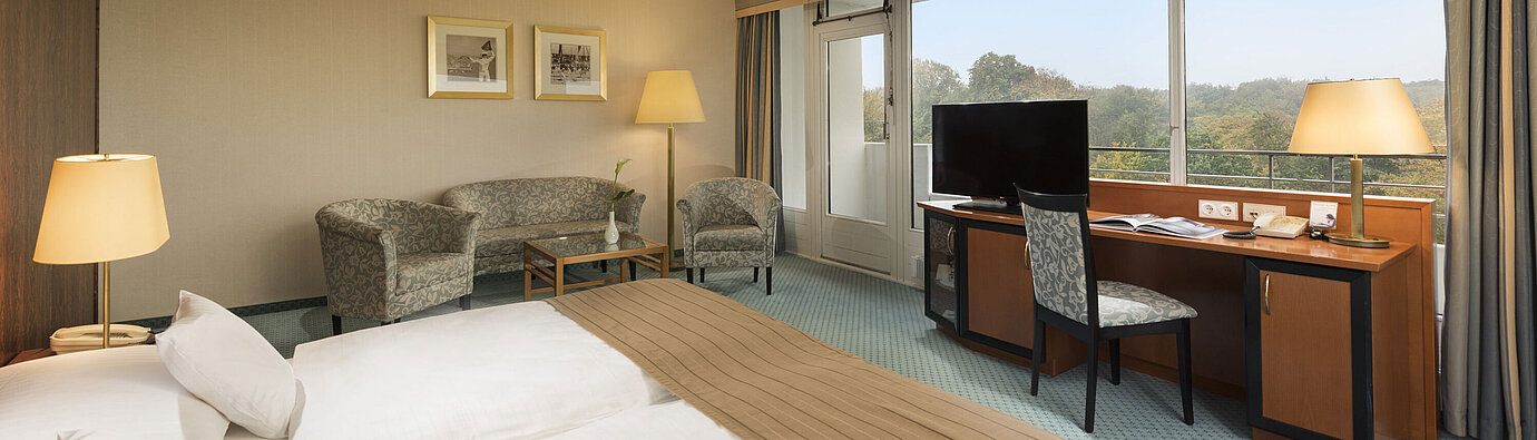 Comfort room Comfort room at the Maritim Hotel Kiel with a cozy seating area, desk, large bed and a wonderful view of the countryside.