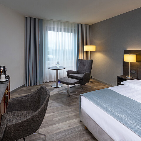 Modernly furnished Superior Smart room with desk, TV, seating area, and comfortable bed at Maritim Hotel Bremen.
