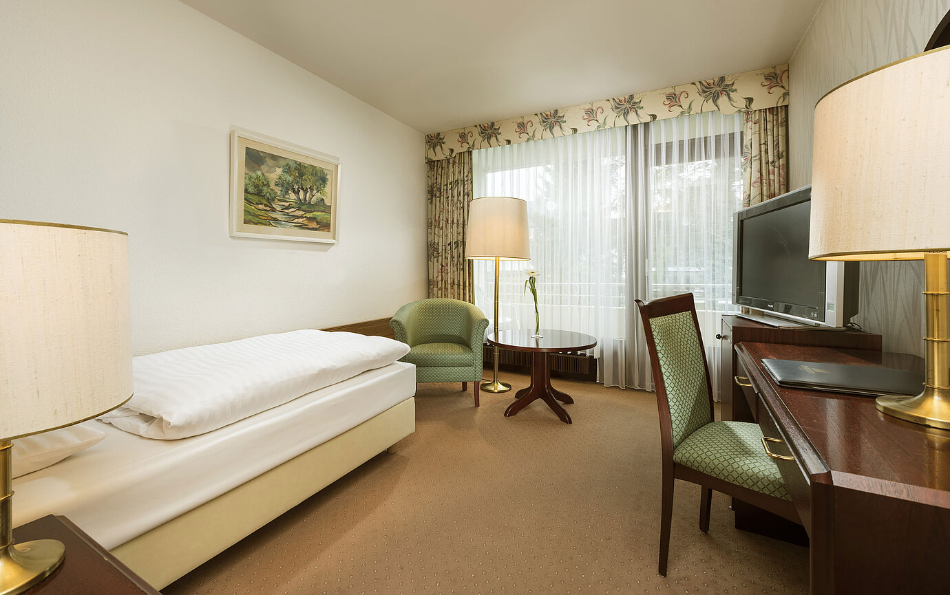 Single room with desk, armchair and balcony access at Maritim Hotel Bad Salzuflen