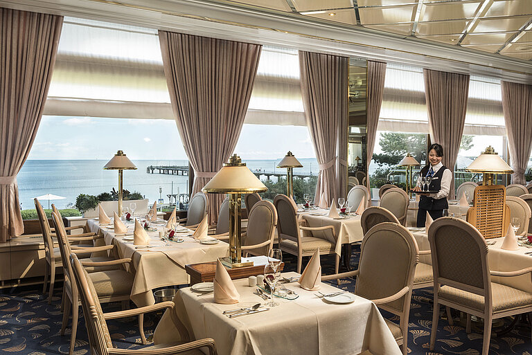 Elegant restaurant with sea view and set tables at Maritim Seehotel Timmendorfer Strand.