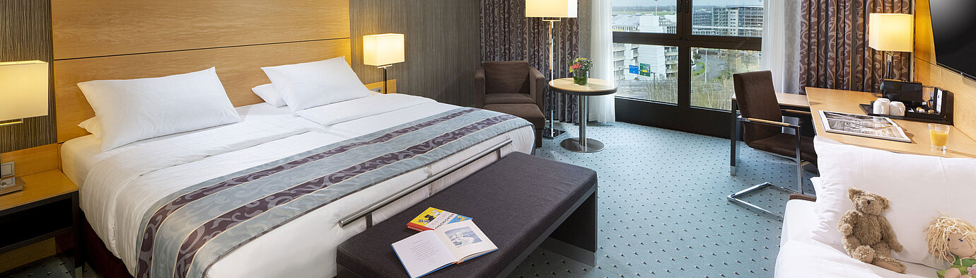 Spacious superior family room at Maritim Hotel Düsseldorf with a large bed, extra bed, and city view.