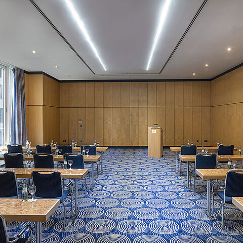 Meeting room Salon IV in the Maritim proArte Hotel Berlin with tables, chairs and lectern.