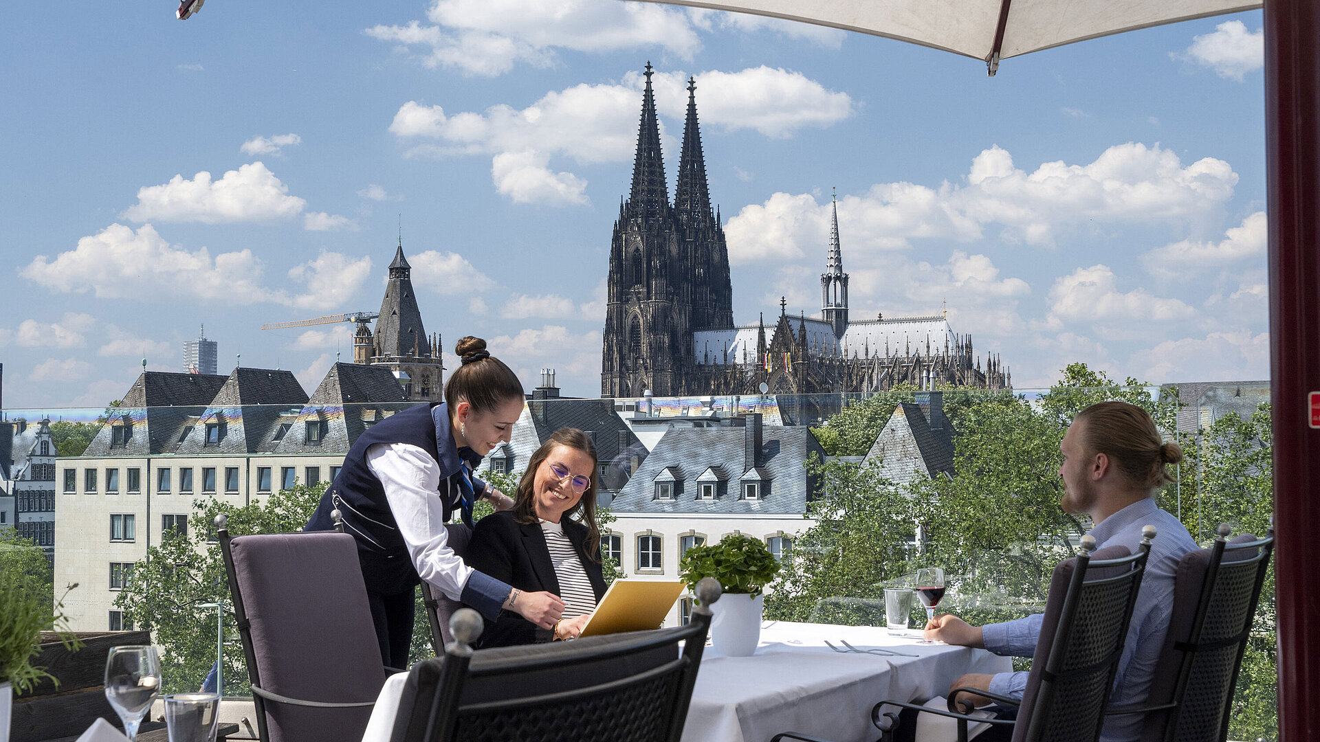 Roof terrace Guests enjoying service on the rooftop terrace of Maritim Hotel Cologne with views of Cologne Cathedral and the Old Town.