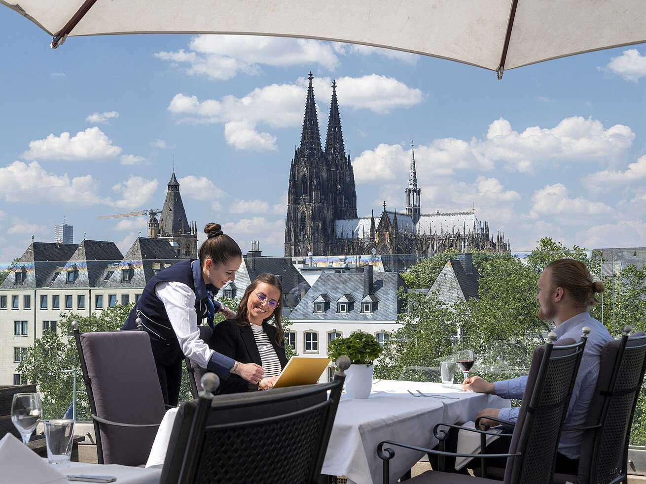 Roof terrace Guests enjoying service on the rooftop terrace of Maritim Hotel Cologne with views of Cologne Cathedral and the Old Town.
