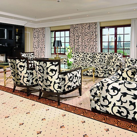 Presidential suite at the Maritim Hotel Dresden with stylish sofas, armchairs, and city view.