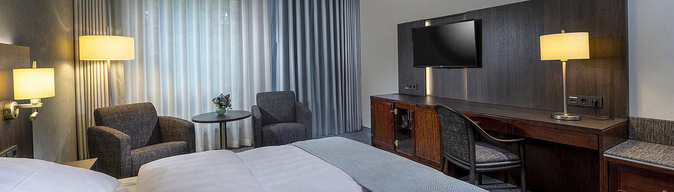 Classic room Modernly furnished Classic room with desk, TV, seating area, and comfortable bed at Maritim Hotel Bremen.