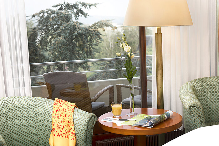 Cosy sitting area at Maritim Hotel Bad Salzuflen with view of the balcony and greenery
