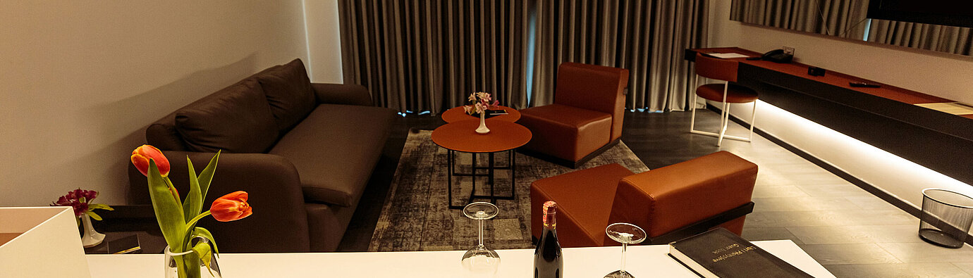 Modern living area at Maritim Resort Marina Bay with sofa, armchairs and cosy seating