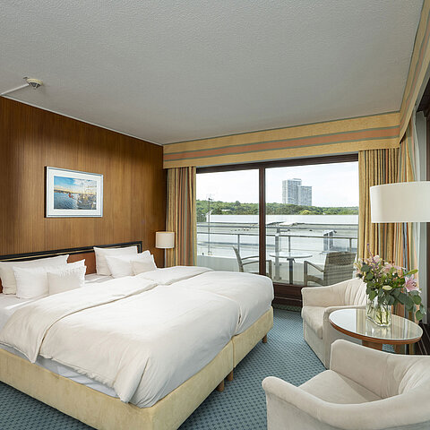 Spacious family suite at Maritim Seehotel Timmendorfer Strand with balcony, sea view, and cozy seating area.