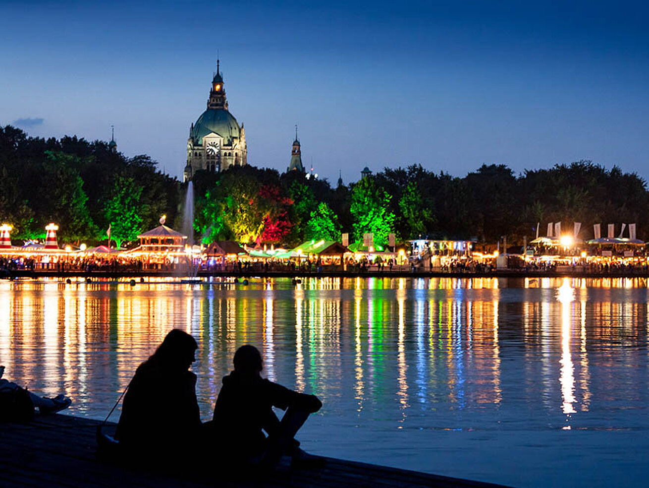 © Sebastian Grote - AdobeStock.com Maschseefest in Hannover bei Nacht mit beleuchtetem Ufer und Spiegelungen auf dem Maschsee