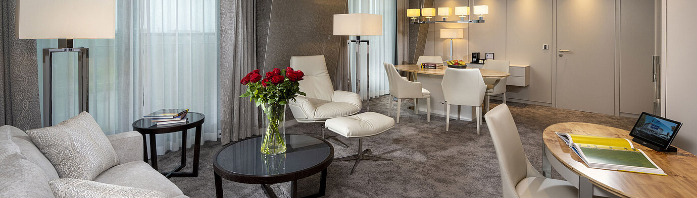 Suite Premium suite with elegant interior, seating area, dining table, and sophisticated decor.