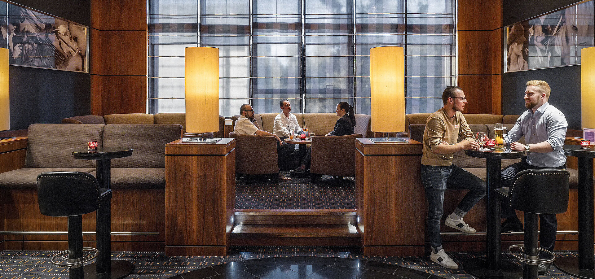 Morley’s Bar Cozy seating areas in the hotel bar at Maritim Hotel Düsseldorf with modern lighting and guests chatting.
