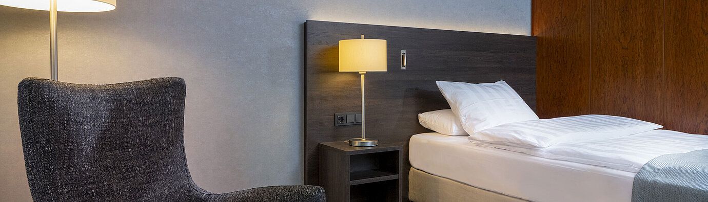 Superior Queen room Modern Superior room at Maritim Hotel Bremen with cozy chair, bedside table, and ambient lighting.