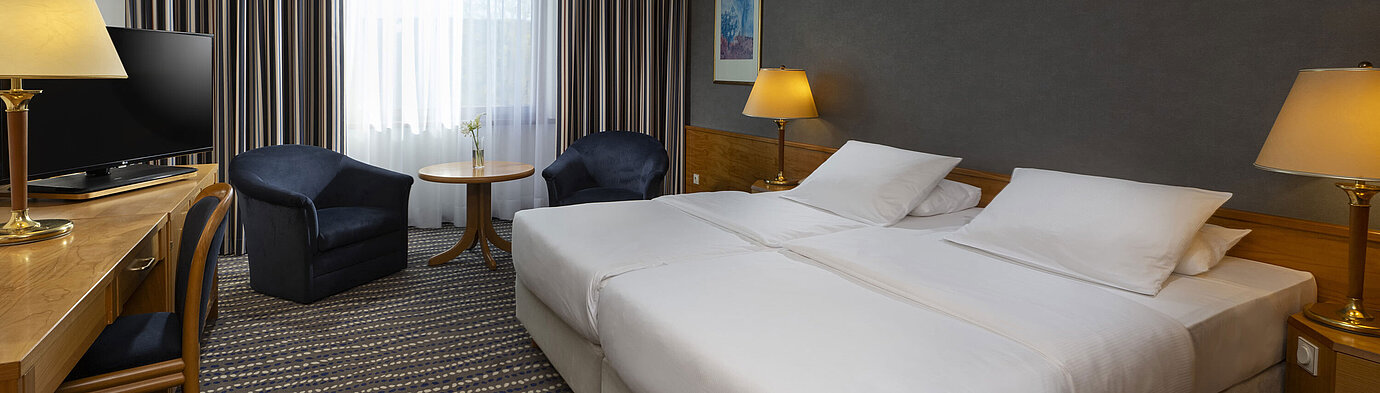 Classic room Hotel room with double bed, TV, desk, and cozy seating area, ideal for relaxation and comfort