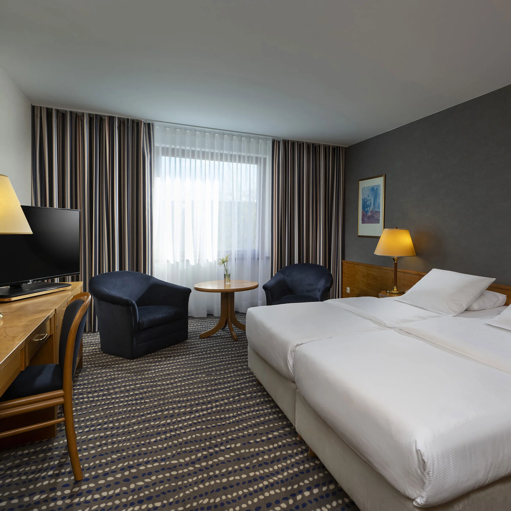 Classic room Hotel room with double bed, TV, desk, and cozy seating area, ideal for relaxation and comfort