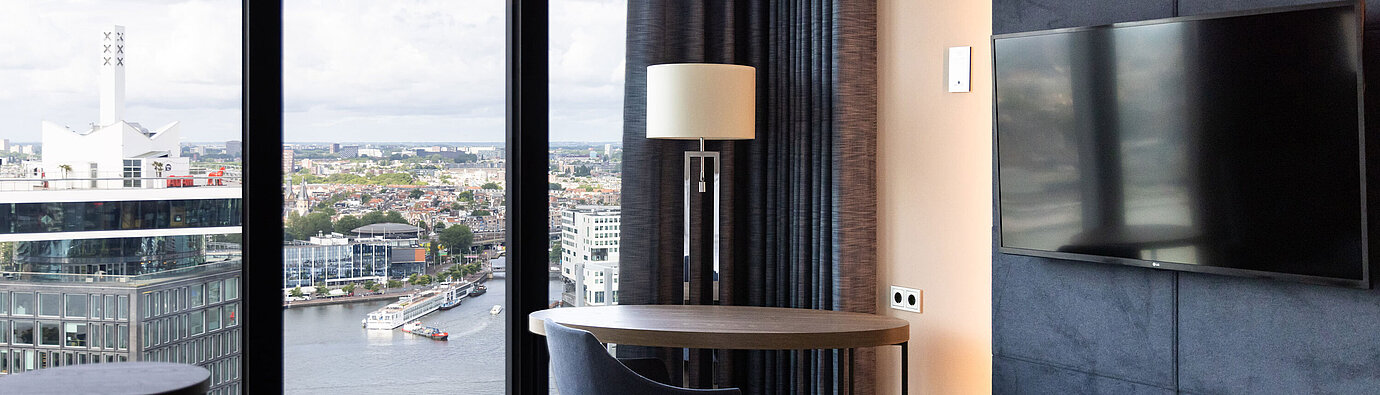 Seating area with table and view over Amsterdam in Maritim Hotel Amsterdam
